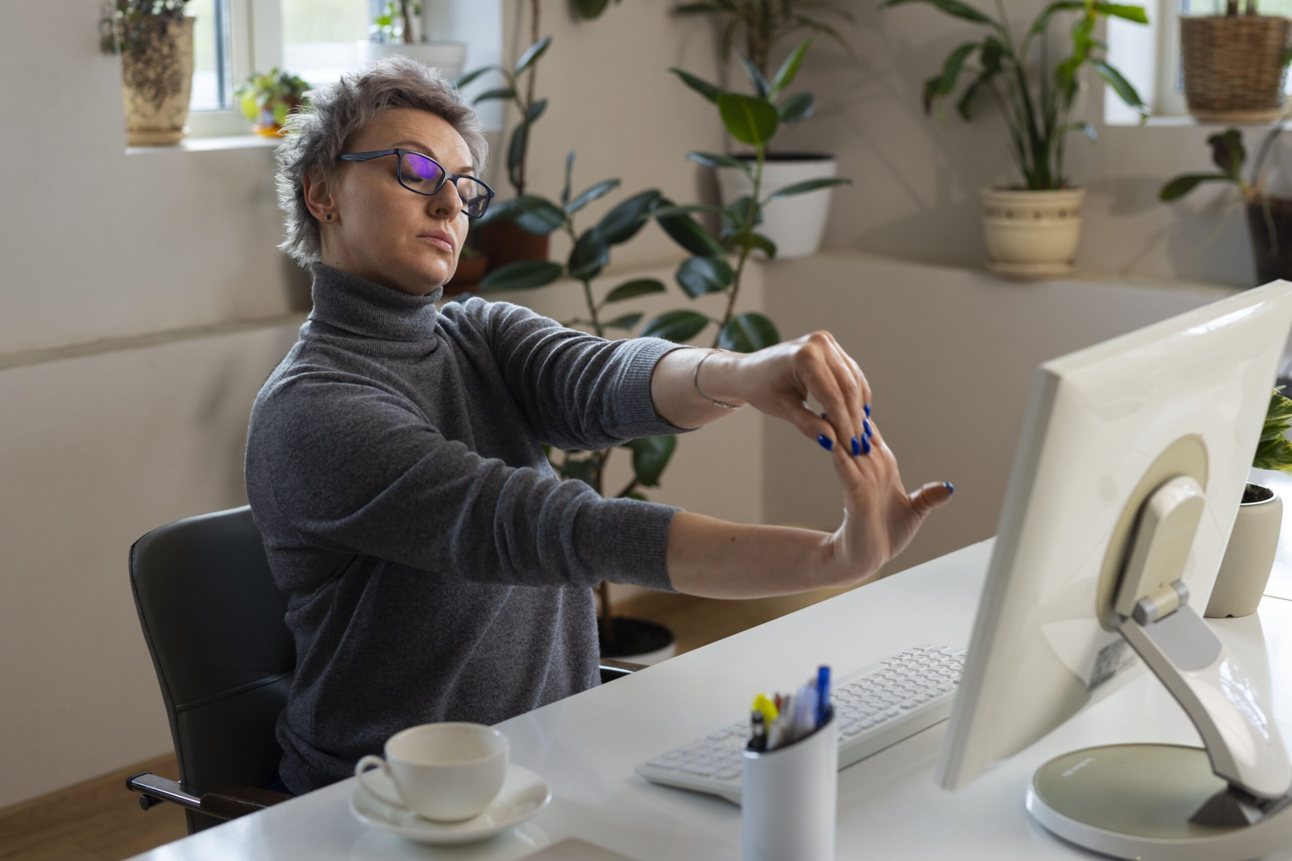 medium-shot-woman-stretching-desk